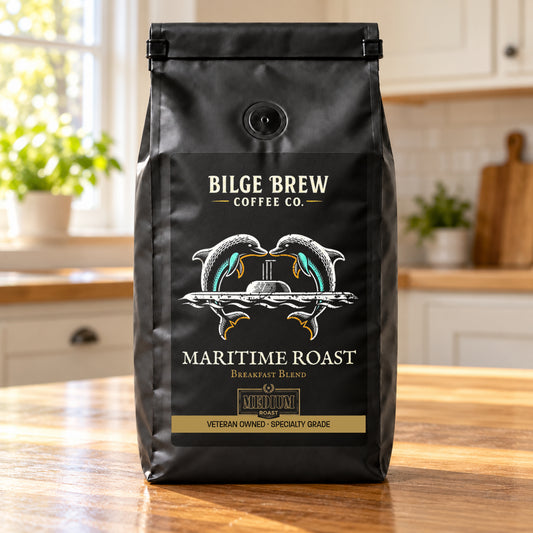 A black coffee bag from Bilge Brew Coffee Co. standing on a wooden kitchen counter, with a blurred kitchen background.
