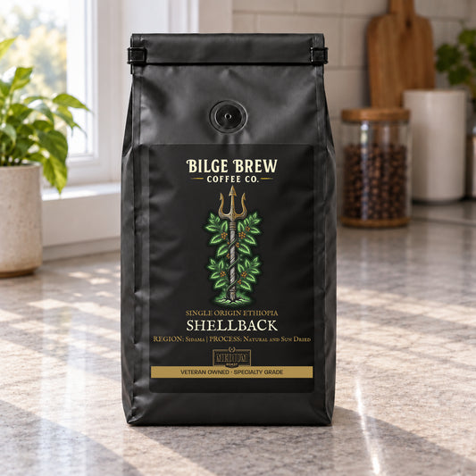 A black coffee bag labeled Bilge Brew Coffee Co. Shellback, standing on a kitchen countertop with a blurred kitchen background.