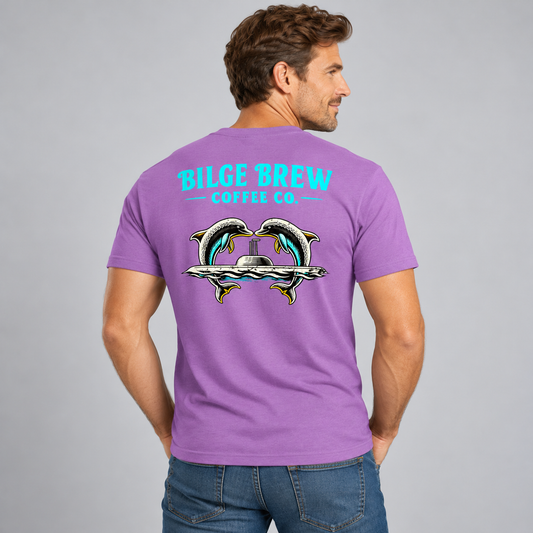 A man wearing a purple t-shirt, viewed from the back. The shirt features a graphic of two dolphins facing each other above a silver submarine, with the text 'BILGE BREW COFFEE CO.