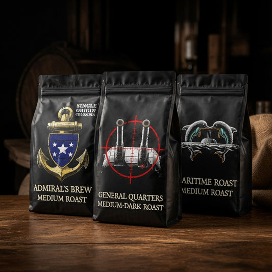 Three black coffee bags with different designs and text on a wooden surface.