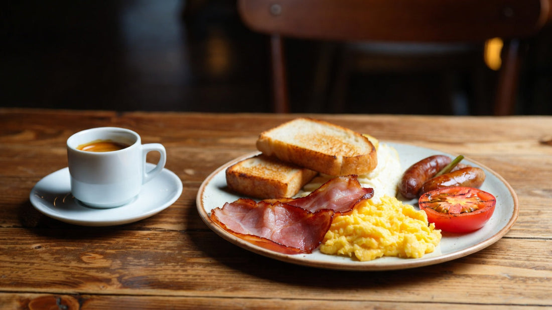 A photograph of a food and drink setup on a wooden table in a cozy indoor setting.