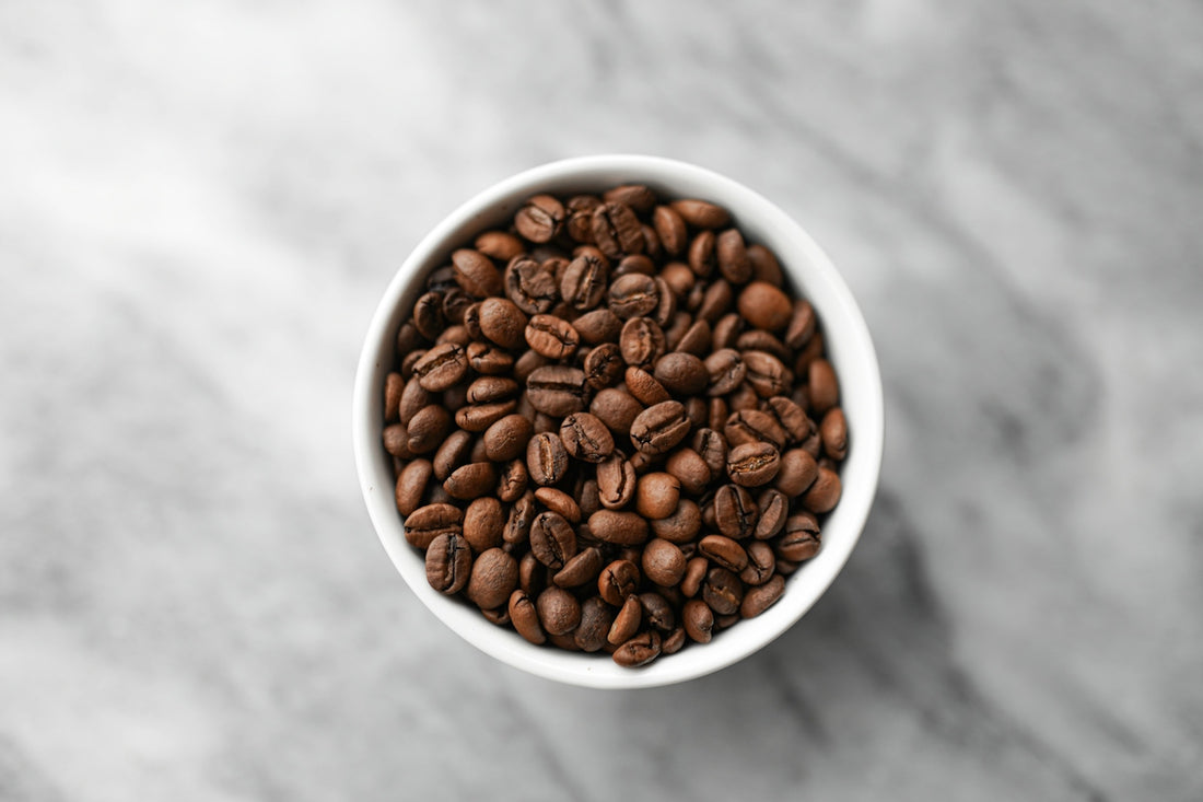 A small white bowl filled with coffee beans
