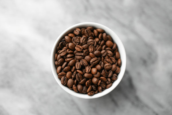A small white bowl filled with coffee beans