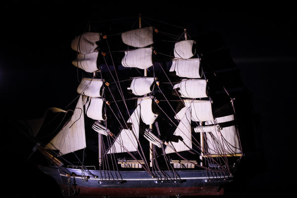 Model sailing ship with white sails