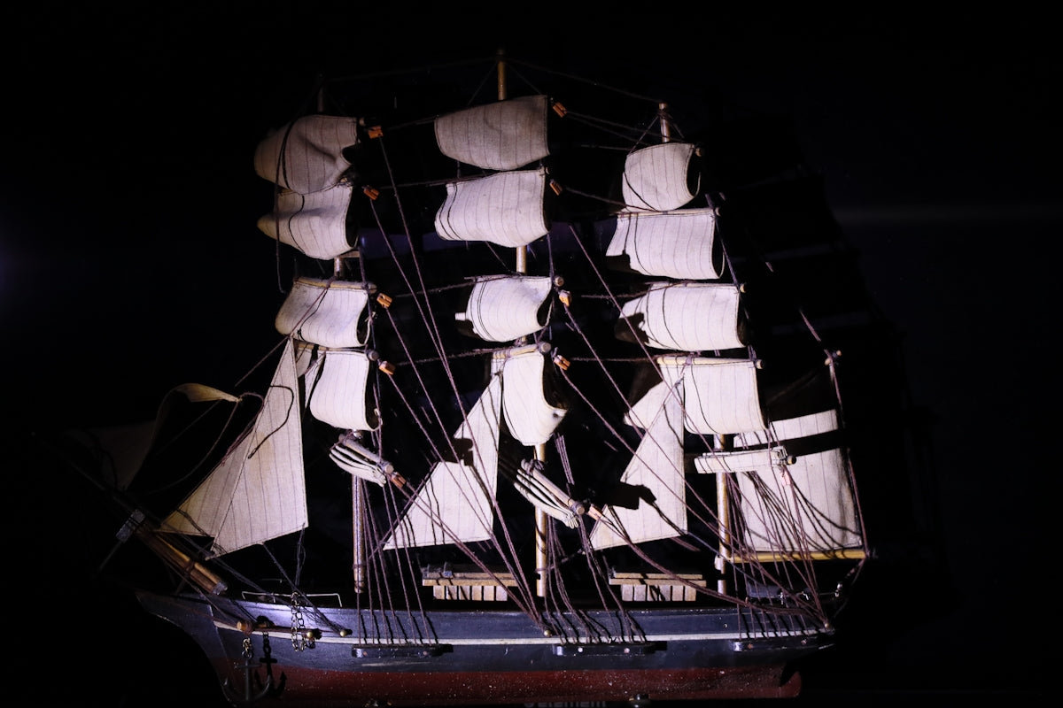 Model sailing ship with white sails