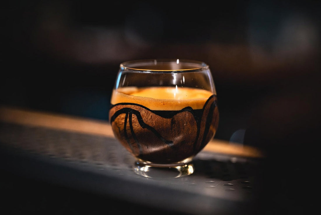 dark, moody, luxurious feel. dark walnut with black epoxy inlay setting. of an artisan glass of espresso, full body crema