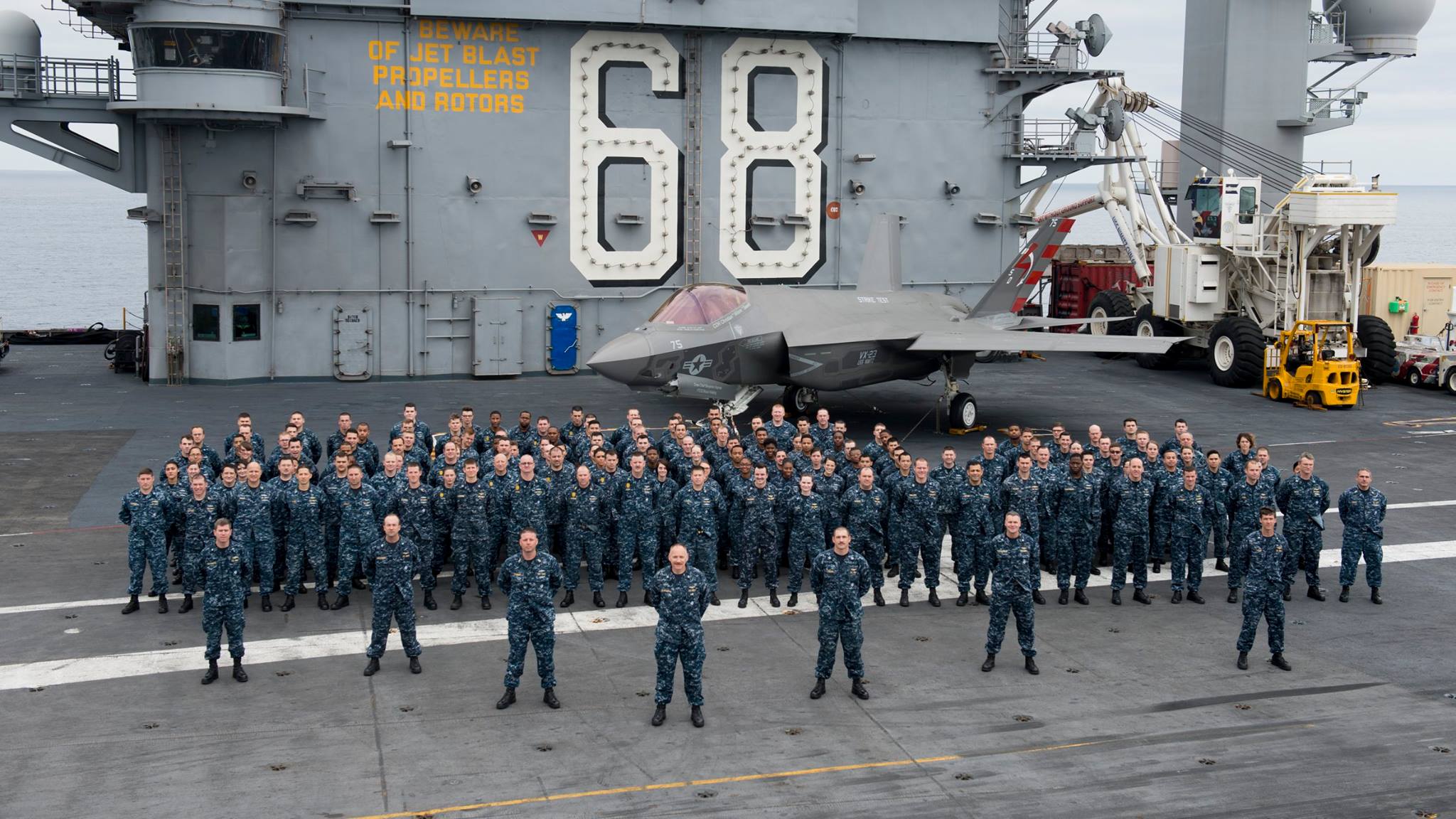 us navy veteran strike group on aircraft carrier with fighter jet
