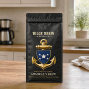 A black coffee bag from Bilge Brew Coffee Co. standing on a wooden countertop in a kitchen setting.