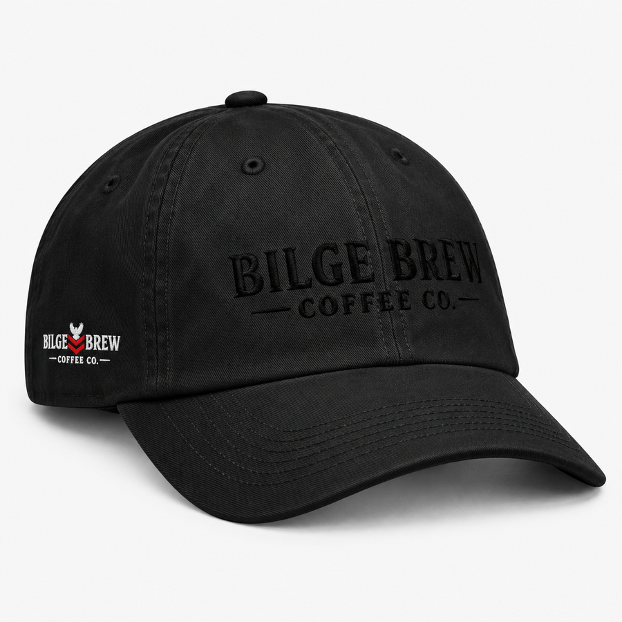 A black washed cotton baseball cap with the phrase 'Bilge Brew Coffee Co' embroidered in white on the front, shown against a white background.