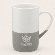 A ceramic coffee mug with a two-tone design, featuring a white speckled upper half and a gray speckled lower half with a printed anchor logo and the text 'BILGE BREW COFFEE CO.' on the front, set against a plain light beige background.