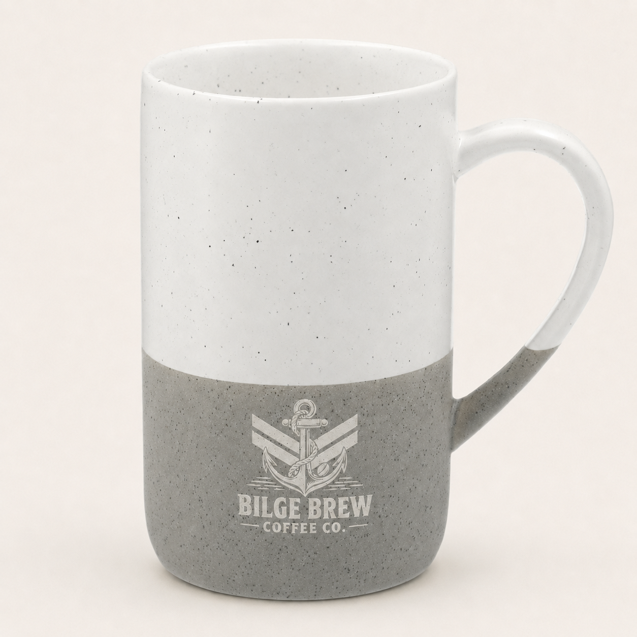 A ceramic coffee mug with a two-tone design, featuring a white speckled upper half and a gray speckled lower half with a printed anchor logo and the text 'BILGE BREW COFFEE CO.' on the front, set against a plain light beige background.