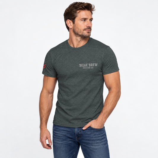 A man wearing a dark heather gray t-shirt with 'BILGE BREW COFFEE CO.' printed on the chest, paired with blue jeans, against a plain white background.