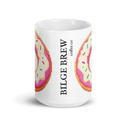 A white ceramic coffee mug featuring a pixel-art donut design in pink, orange, and beige with colorful sprinkles, alongside the vertical text 'BILGE BREW coffee co'.