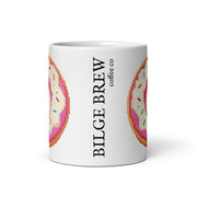 A white ceramic coffee mug featuring a pixel-art donut design in pink, orange, and cream, with the vertical text 'BILGE BREW' and smaller text 'coffee co' printed on the side.