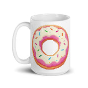 A white ceramic mug featuring a pixel-art style graphic of a donut with pink frosting and colorful sprinkles, shown on a clean white background.