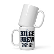 Two white ceramic mugs stacked on a white background, with the bottom mug printed in bold black text reading 'BILGE BREW' and smaller text 'WAKE THE HELL UP.' above a small anchor graphic.