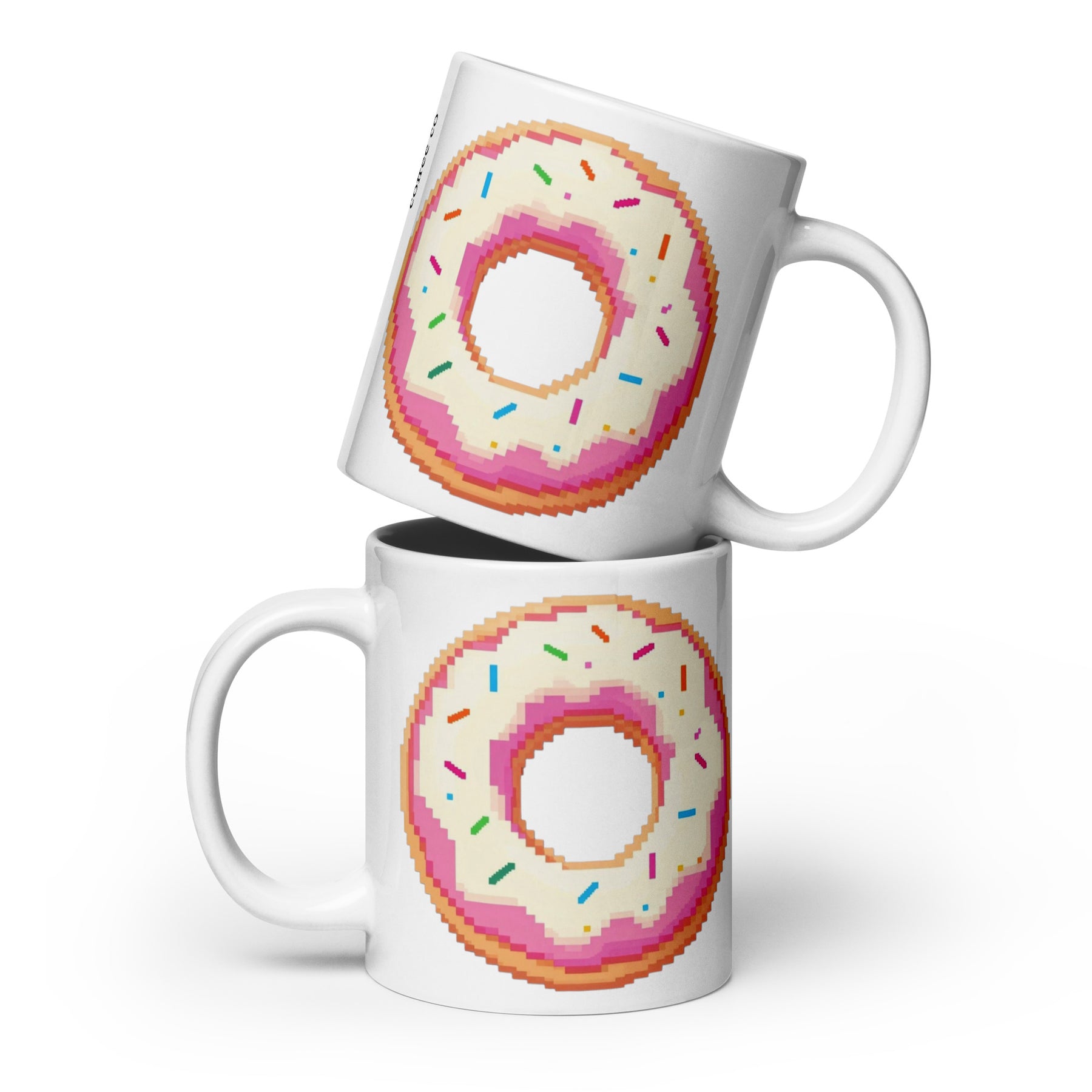 Two white ceramic mugs stacked with a pixel-art donut design featuring pink frosting and multicolored sprinkles, shown on a clean white background.