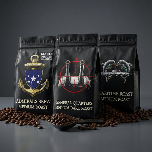 Three black coffee bags with different designs and text on a gray background with scattered coffee beans.
