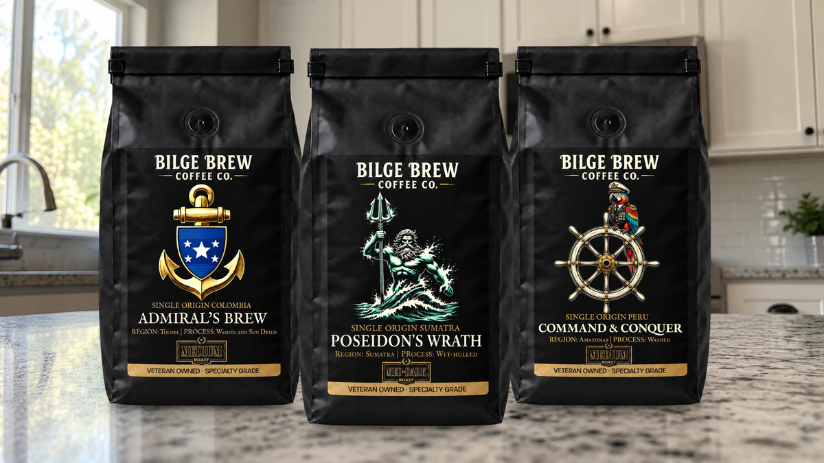 Three black bags of Bilge Brew Coffee Co. specialty coffee stand side by side on a kitchen countertop.