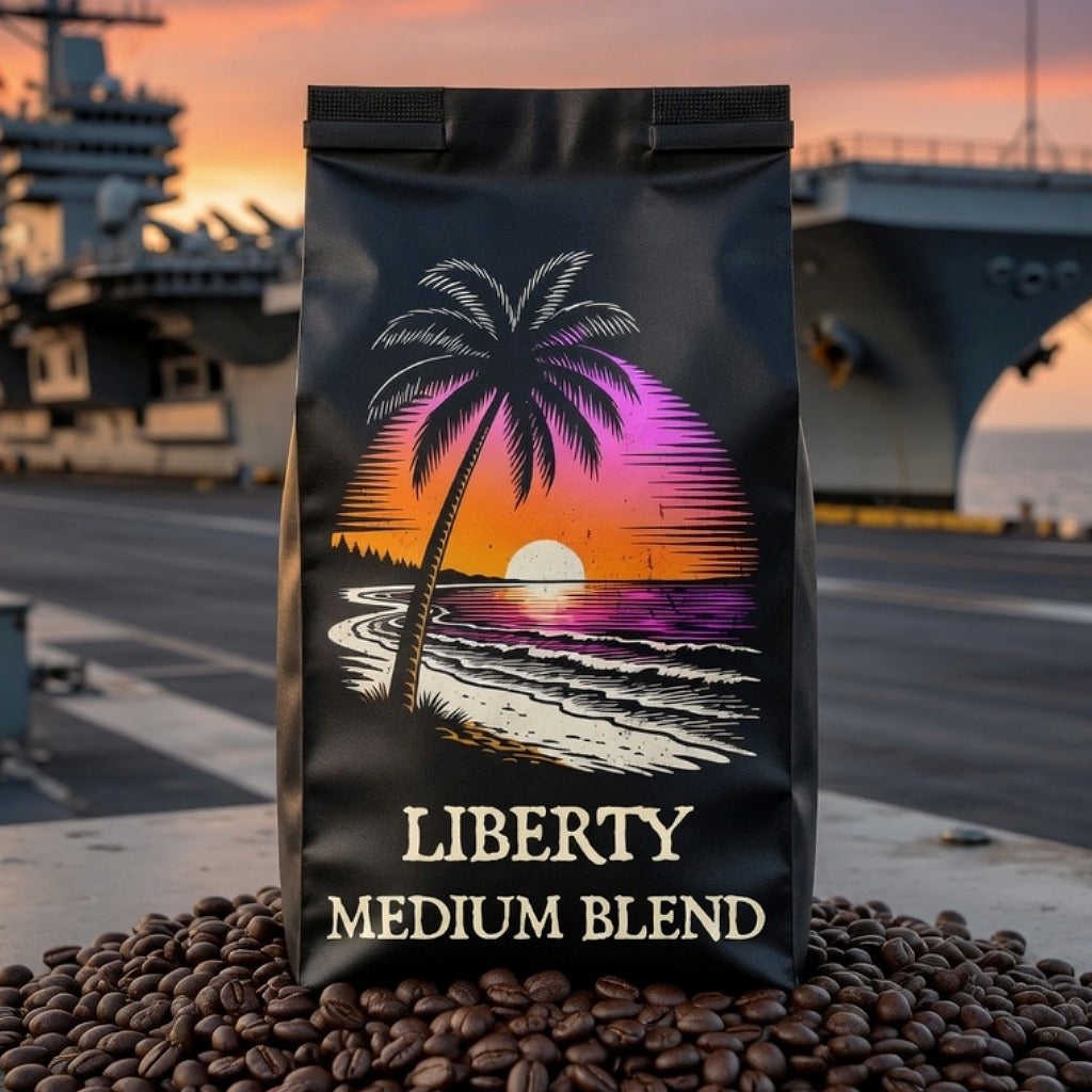 Coffee bag labeled 'Liberty Medium Blend' with a palm tree and sunset design, placed on coffee beans with a blurred aircraft carrier in the background.