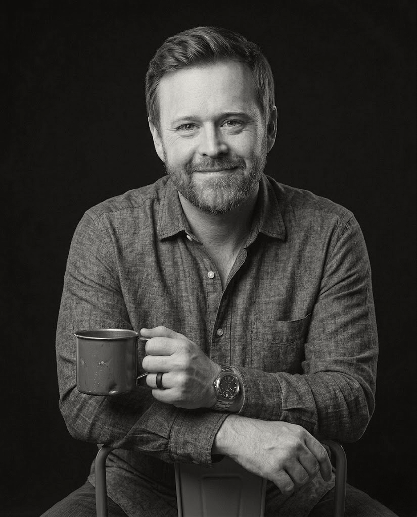 Man holding a mug against a black background