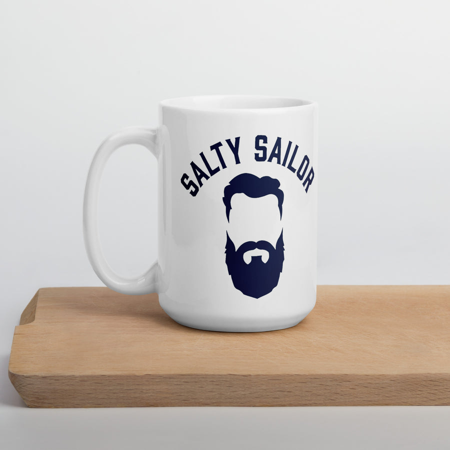 White mug with 'Salty Sailor' design featuring a beard illustration on a wooden surface.