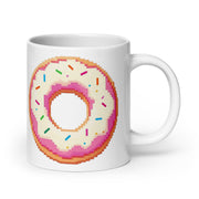 A white ceramic mug featuring a pixel-art style graphic of a donut with pink frosting and colorful sprinkles, shown on a clean white background.
